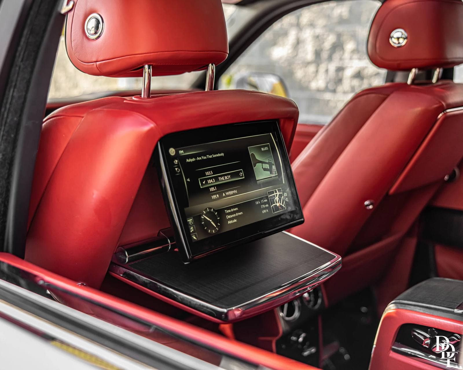 Rear cabin of a Rolls-Royce from the DDE Rentals fleet, red leather with picnic tables and theatre screens